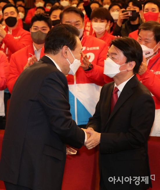 윤석열 대통령 당선인이 10일 서울 여의도 국회도서관에 마련된 국민의힘 개표상황실을 찾아 안철수 국민의당 대표와 악수를 나누고 있다./윤동주 기자 doso7@