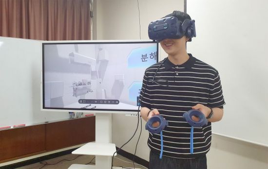 부경대 대학원생이 VR 교육 시스템을 체험하고 있다.