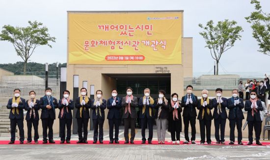 박완수 경남지사(왼쪽에서 일곱 번째)를 비롯한 개관식 참석자들이 개관 축하 리본을 자른 후 박수를 치고 있다.