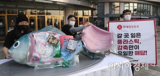 그린피스 활동가들이 25일 서울 송파구 롯데칠성음료 본사 앞에서 기업의 플라스틱 감축을 요구하며 플라스틱 쓰레기를 삼킨 대형 물고기 퍼포먼스를 하고 있다. /문호남 기자 munonam@