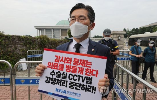 이필수 대한의사협회장이 2021년 8월 서울 여의도 국회 앞에서 열린 수술실 내 CCTV 설치 의무화법안 국회 본회의 부결 촉구 기자회견에서 법안 부결을 촉구하는 손피켓을 들고 있다. / [사진출처=연합뉴스]