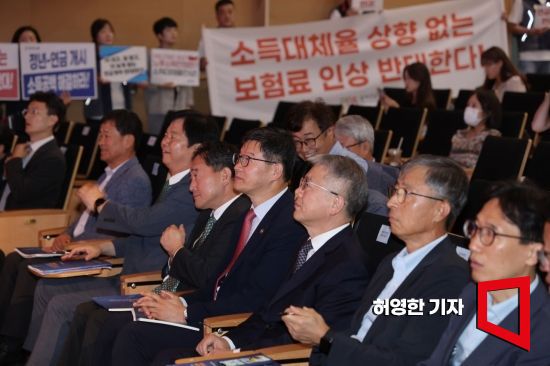 1일 코엑스에서 열린 제5차 국민연금 재정계상 공청회에서 재정계상위원회 위원들이 앉아 있는 옆에서 민주노총과 참여연대 등 단체 회원들이 국민연금 개악에 반대하는 피켓을 들고 서 있다. 사진=허영한 기자 younghan@