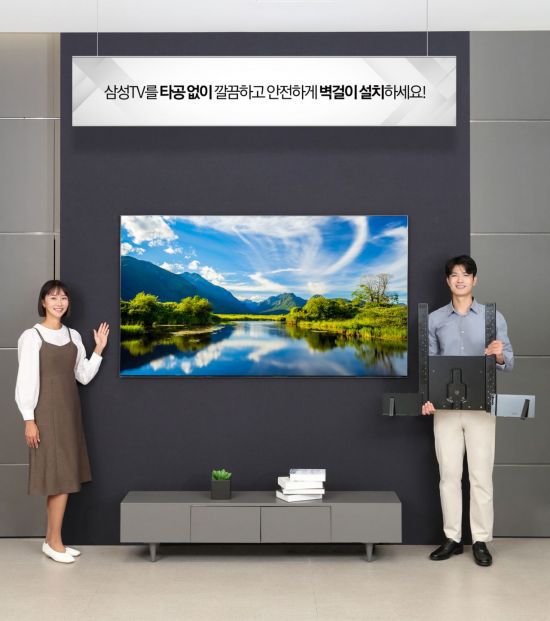 삼성전자 모델이 삼성스토어 대치점에서 '삼성 TV 무타공 솔루션'을 소개하고 있다. 벽면에 구멍을 뚫는 타공을 하지 않아도 벽걸이 TV를 깔끔하게 설치할 수 있다.[사진제공=삼성전자]