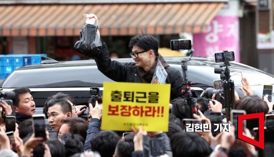 한동훈 국민의힘 비상대책위원장이 설 연휴를 나흘 앞둔 5일 서울 동대문구 청량리 청과물시장·경동시장을 방문해 구매한 상품을 들어보이며 시민들과 인사를 나누고 있다. 사진=김현민 기자 kimhyun81@