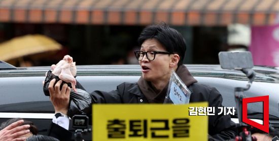 한동훈 국민의힘 비상대책위원장이 설 연휴를 나흘 앞둔 5일 서울 동대문구 청량리 청과물시장·경동시장을 방문해 구매한 상품을 들어보이며 시민들과 인사를 나누고 있다. 사진=김현민 기자 kimhyun81@