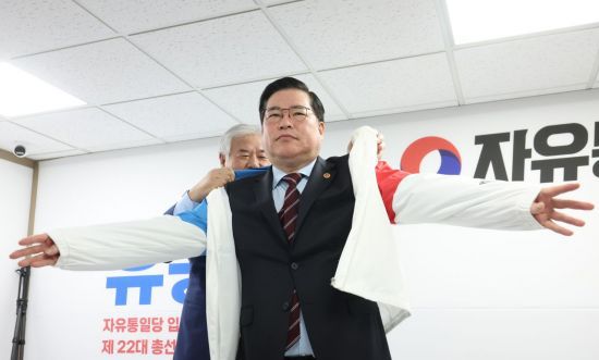 유동규 전 성남도시개발공사 기획본부장이 14일 여의도 자유통일당 당사에서 총선 출마 선언에 앞서 전광훈 목사로부터 당 점퍼를 받아 입고 있다. [이미지출처=연합뉴스]