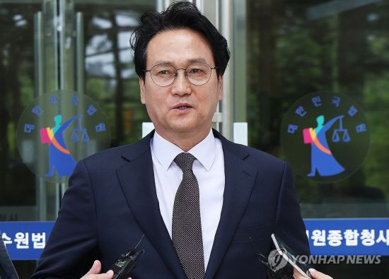 최서원(개명 전 최순실)씨에 대한 명예훼손 혐의로 기소된 안민석 더불어민주당 의원이 23일 오전 경기도 수원시 영통구 수원지방법원에서 열린 첫 공판을 마치고 나와 취재진의 질문에 답하고 있다.