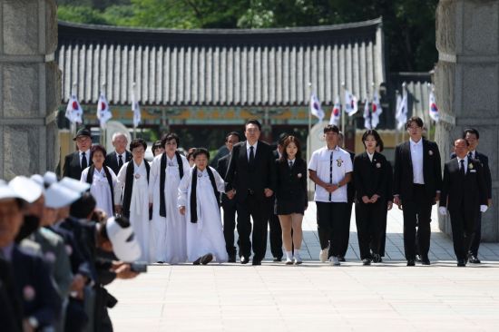 윤석열 대통령이 18일 광주시 북구 국립5·18민주묘지에서 열린 제44주년 5·18민주화운동 기념식에서 5·18 유가족 대표들과 함께 입장하고 있다. [이미지출처=연합뉴스]