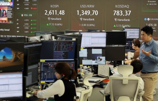 9일 한국 국채의 세계국채지수(WGBI) 편입이 결정된 후 첫 거래일인 10일 코스피는 소폭 상승한 2610포인트대로 출발하고 코스닥도 소폭 상승했다. 서울 을지로 하나은행 딜링룸에서 직원들이 업무를 보고 있는 가운데 전광판에 주가와 환율 등 지수들이 표시되고 있다. 사진=허영한 기자 younghan@
