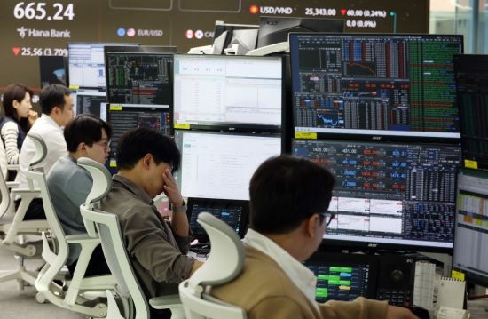 윤석열 대통령이 비상계엄을 선언했다 국회의 의결로 계엄을 해제한 4일 서울 중구 하나은행 딜링룸 관계자들이 굳은 표정을 짓고 있다.