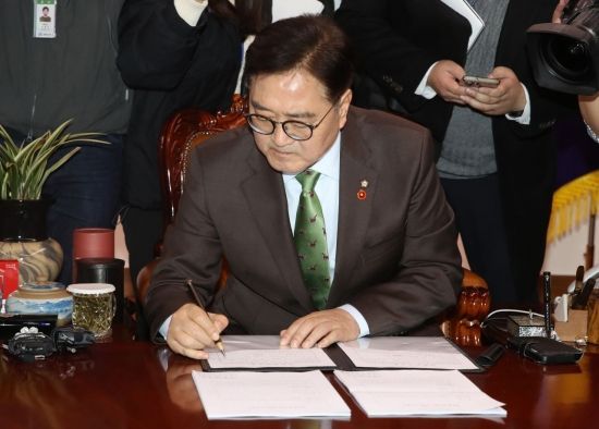 우원식 국회의장이 14일 국회에서 윤석열 대통령 탄핵소추 의결서에 서명하고 있다.