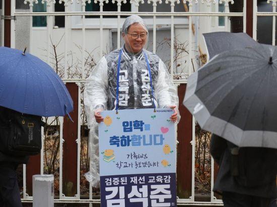 김석준 부산교육감 재선거 예비후보가 4일 기장군 모전초교 앞에서 등교하는 학생들에게 입학 축하 인사를 건네고 있다.