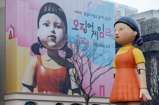 넷플릭스 오리지널 시리즈 '오징어게임' 시즌2의 공개일인 지난해 12월 26일 서울 종로구 광화문광장에 오징어게임 캐릭터 '영희' 조형물과 홍보 현수막이 설치돼 있다. 강진형 기자