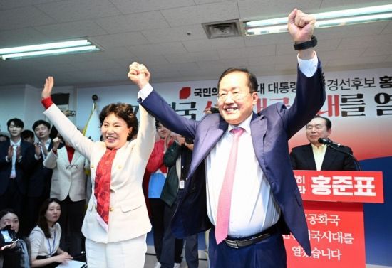 홍준표 전 대구시장이 지난 4월 14일 서울 여의도 대하빌딩 캠프 사무소에서 제21대 대통령 선거 출마 선언하며 부인 이순삼 씨와 함께 손을 들어보이고 있다. 사진=김현민 기자