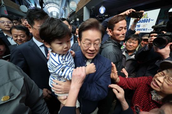 이재명 더불어민주당 대선 후보가 '골목골목 경청투어' 접경지역 방문 이틀째인 2일 강원 철원군 동송시외버스고용터미널 인근에서 어린이를 안아주고 있다. 연합뉴스