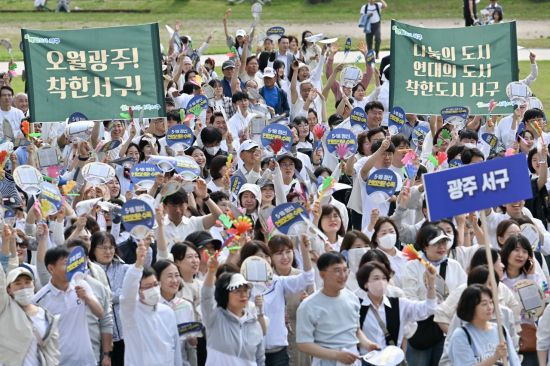 광주 서구청 공무원과 주민들이 ‘오월정신, 6월 3일 투표로 계승합시다’라는 문구가 적힌 현수막과 손팻말을 들고 있다. 서구 제공