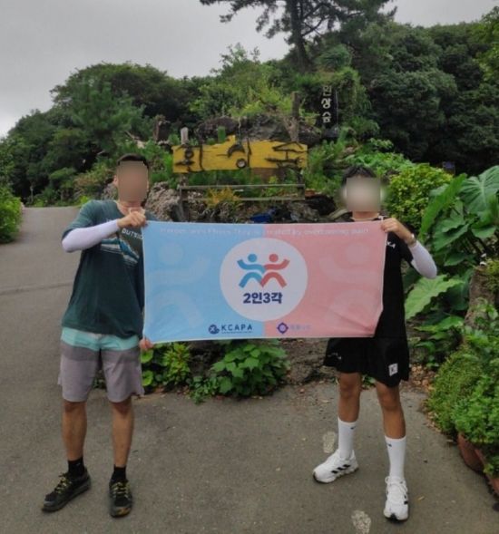 아동학대 피해자 김모씨(35)와 아동이 지난해 8월 '2인3각 제주도 도보여행'에서 기념 사진을 찍고 있다. 대한아동학대방지협회 제공