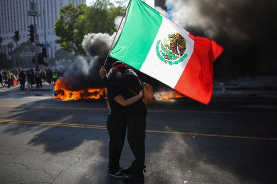 미국 캘리포니아주 로스앤젤레스 도심에서 연방 이민 단속에 반대하는 시위가 열린 가운데 시위대가 멕시코 국기를 들고 있다. 로이터연합뉴스.