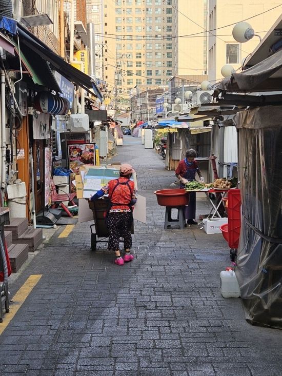지난 10일 오전 한 노인이 서울 중구 신당중앙시장에서 폐지를 실은 수레를 끌고 가고 있다. 박승욱 기자