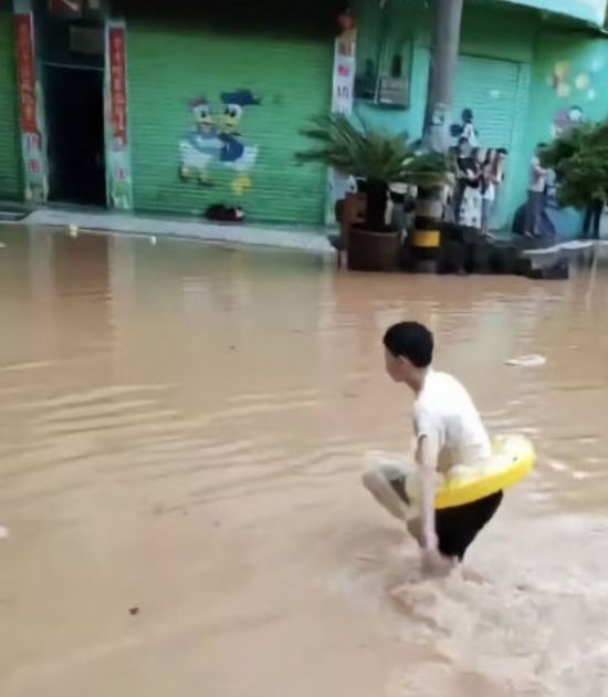 폭우에 한 학생이 튜브를 타고 학교에 도착했다. 웨이보.