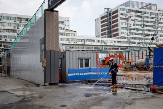 서울 한 건설현장에서 한 노동자가 지열을 식히기 위해 물을 뿌리고 있다. 강진형 기자