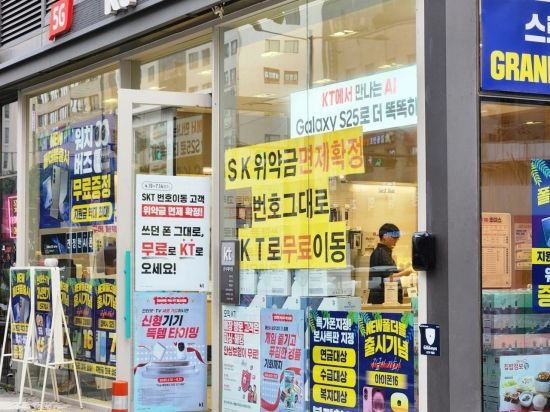 6일 서울 강동구 KT 대리점에 붙은 마케팅 문구들. "SK 위약금 면제 확정. 번호 그대로 KT로 무료이동" 이라는 글귀가 적혀있다. 사진=박유진 기자