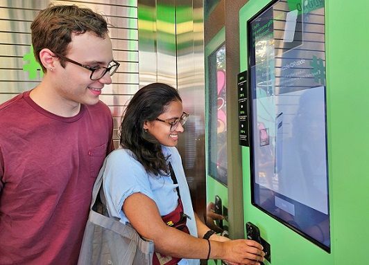 미국인 탄비(Tanvi, 오른쪽)씨와 러셀(Russell, 왼쪽)씨가 올리브영 명동 타운에 마련된 벤딩머신으로 글로벌몰에 가입하는 모습. CJ올리브영 제공.