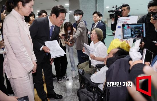 이재명 더불어민주당 대표가 2023년 국회 의원회관에서 열린 토론회에 참석하던 중 전국장애인차별철폐연대(전장연) 관계자들을 만나 장애인복지법 관련 건의사항을 듣고 있다. 사진=김현민 기자 kimhyun81@