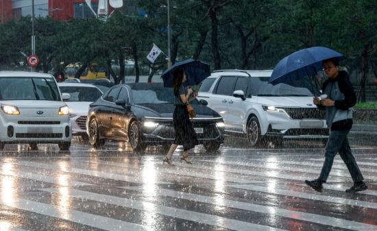 서울 전역에 호우주의보가 발령된 17일 서울 여의도 버스환승센터에서 직장인들이 우산을 꼭 붙잡고 출근길에 오르고 있다. 2025.7.16. 강진형 기자