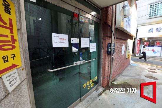 서울 종로구 서울대병원 근처 약국과 식당들이 있는 거리의 한 식당 앞에 폐업 안내문이 붙어있다. 사진=허영한 기자 younghan@