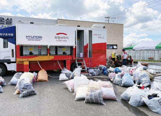 충남 아산 미래농업인센터 앞에 설치된 희망브리지 세탁구호차량. 수해 피해를 입은 이재민들의 의류와 이불 등을 수거해 현장에서 직접 세탁·건조하는 작업이 진행되고 있다. 희망브리지