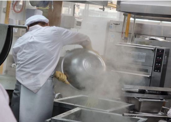 광주의 한 학교 급식실에서 조리 노동자가 뜨거운 증기가 피어오르는 조리통 앞에서 작업하고 있다. 학교비정규직노조 제공