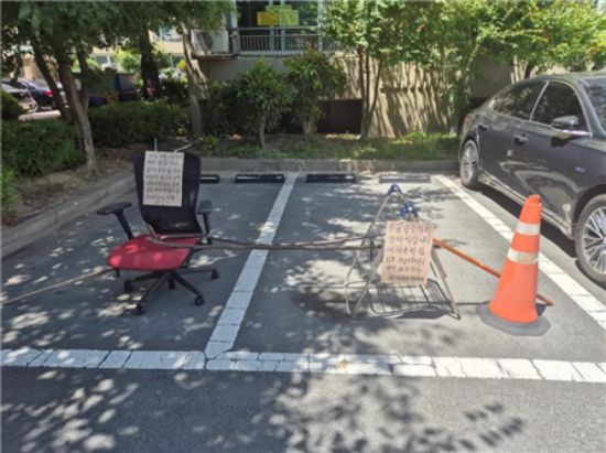 누리꾼이 공개한 주차장 점거 모습. 의자와 건조대 등으로 차량 진입을 막은 모습이다. 온라인 커뮤니티