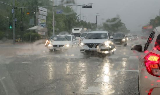 서울ㆍ수도권에 집중호우가 쏟아진 13일 경기도 고양시에서 차량들이 물에 잠긴 도로를 달리고 있다. 연합뉴스