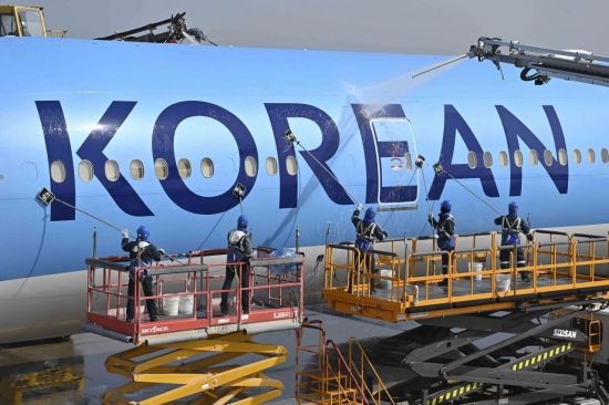 인천 중구 대한항공 항공기 정비고에서 대한항공 관계자들이 새로운 CI가 적용된 항공기 동체를 세척하고 있다. 강진형 기자