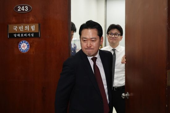 국민의힘 한동훈 대표가 지난해 12월 11일 오후 서울 여의도 국회 당대표실에서 장동혁 의원이 나가는 사이 미소를 짓고 있다. 두 사람의 결별을 상징하는 장면이다. 연합뉴스