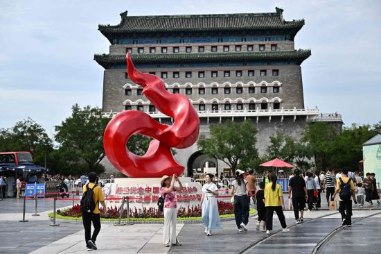 28일 중국 베이징 첸먼 거리의 '중국인민 항일전쟁 및 세계 반(反)파시스트전쟁 승리 80주년(전승절 80주년)' 기념 조형물 앞에 사람들이 모여 있다. AFP 연합뉴스