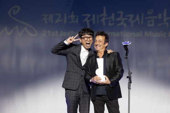 장항준 집행위원장과 올해 제천영화음악상 수상자 에릭 세라가 4일 오후 충북 제천시 제천비행장에서 열린 제21회 제천국제음악영화제 개막식 무대에서 기념 사진을 촬영하고 있다. 사진제공=제천국제음악영화제