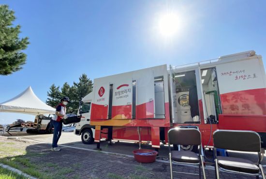 강릉시 청소년해양수련원 주차장에 설치된 희망브리지 이동식 세탁구호차량. 자원봉사자가 세탁물을 옮기고 있다. 희망브리지