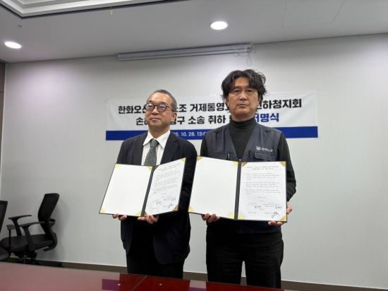 한화오션과 금속노조 경남 거제통영고성 조선하청지회 관계자가 손해배상 청구소송 취하 합의문을 들고 사진을 찍고 있다. 금속노조 경남지부 제공