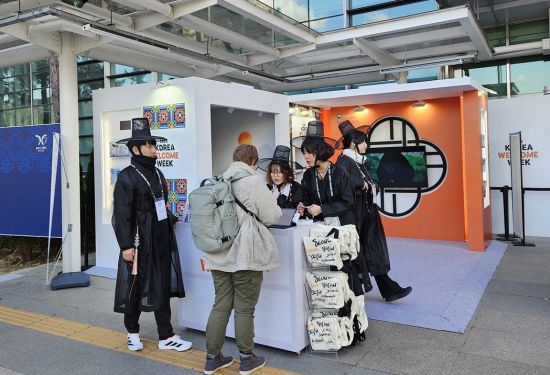 아시아태평양경제협력체(APEC) 정상회의 기간 코레일이 경주역에 설치한 홍보부스에서 애니메이션 영화 '케이팝 데몬헌터스(K-Pop Demon Hunters)' 캐릭터로 분장한 안내 인력이 외국인 방문객에게 행사를 소개하고 있다. 코레일