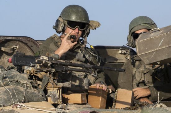 이스라엘 병사가 장갑차 위에서 손짓하며 가자지구 동쪽 지역으로 진입하기 위해 국경 철책 인근 게이트 쪽으로 이동하고 있다. UPI연합뉴스