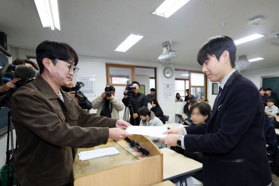 5일 광주 서구 화정동 서석고등학교에서 2026학년도 대학수학능력시험 만점자 재학생 최장우군이 성적표를 받고 있다. 연합뉴스
