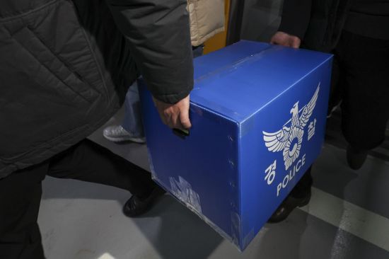 서울 송파구 쿠팡 본사에서 압수수색을 마친 경찰 관계자들이 상자를 들고 이동하고 있다. 연합뉴스