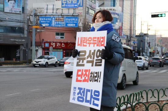 정다은 광주광역시의원이 14일 오전 광주 북구청 앞 사거리에서 ‘내란 우두머리 윤석열 단죄하라’는 문구가 적힌 피켓을 들고 1인 시위를 벌이고 있다.