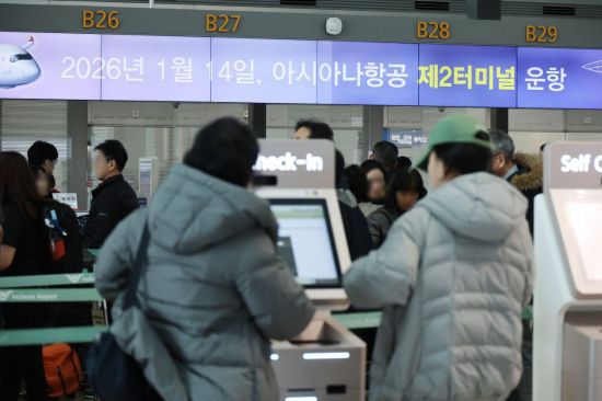 셀프 체크인 키오스크를 이용하고 있는 여행객들의 모습. 연합뉴스