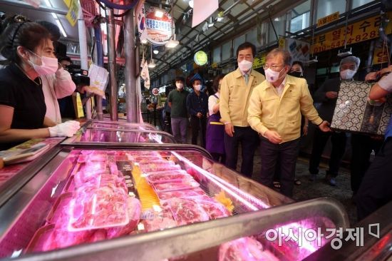 권칠승 중소벤처기업부 장관이 서울 서대문구 영천시장에서 한우를 구매한 뒤 상인과 대화를 나누고 있다. /문호남 기자 munonam@