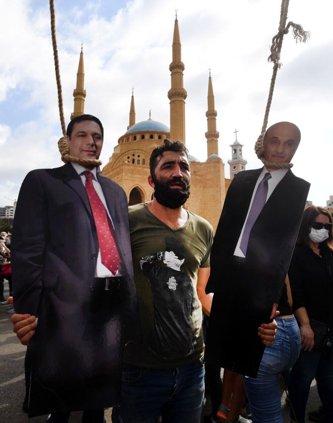 레바논 반정부 시위대가 하산 디아브(왼쪽) 총리를 교수형하는 퍼포먼스를 하고 있다 (사진=AFP)