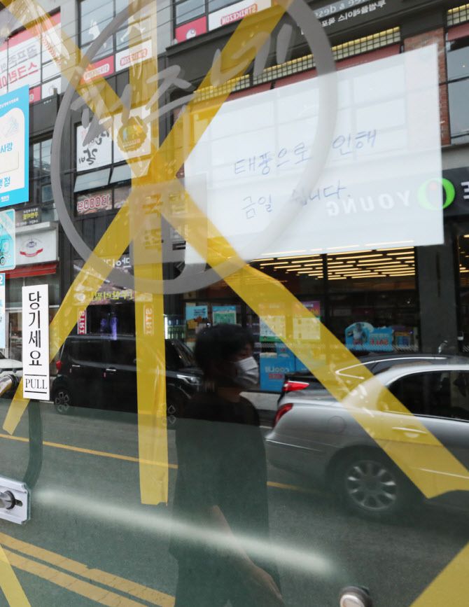 제8호 태풍 ‘바비’가 북상하는 26일 오전 전남 목포시의 한 식당이 출입문에 테이프를 붙이는 등 태풍 피해에 대비한 채 휴업 안내문이 붙어있다.(사진=연합뉴스)