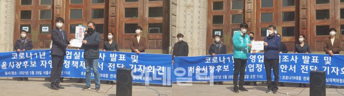 전국자영업자비상대책위 소속 자영업 대표들이 29일 서울 중구 서울광장 앞에서 열린 기자회견에서 서울시장 후보인 박영선 더불어민주당 선거캠프(왼쪽)와 신지혜 기본소득당 선거캠프 관계자에게 자영업 정책 질의서를 전달하고 있다.(사진=이소현 기자)